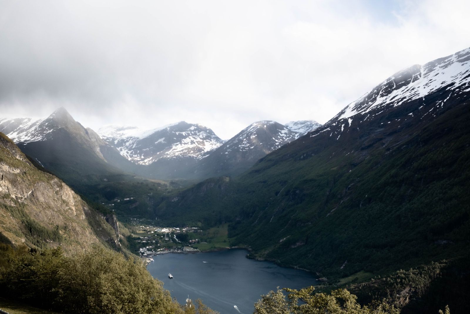Snow-capped mountains above the Geirangerfjord and Geiranger village, one of the best places to visit in Norway